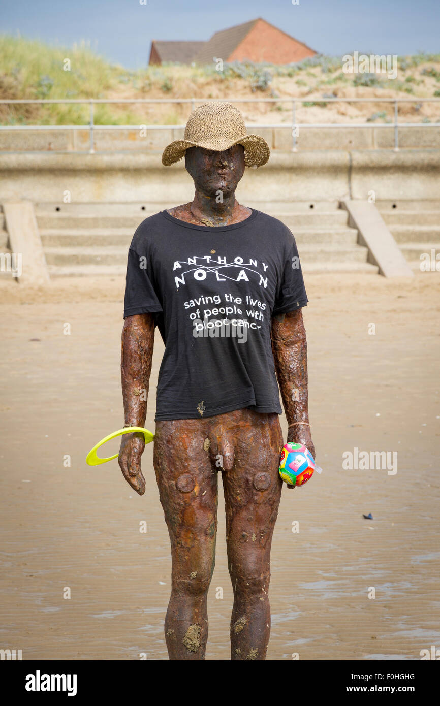 Antony Gormleys ein weiterer Ort Skulptur auf Crosby Strand trug ein T-shirt und Hut Stockfoto