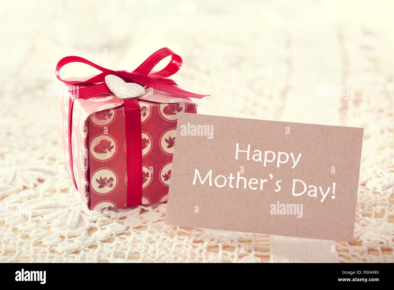 Glückliche Mütter Tag Nachricht geschrieben auf einer Karte mit einer Hand gestaltete Geschenkbox Stockfoto