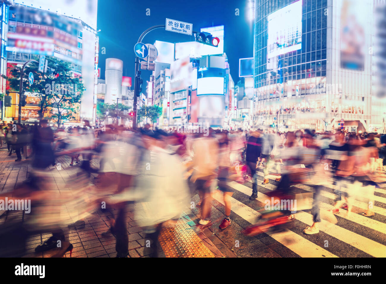 Personen und Fahrzeuge überqueren Sie die berühmte beschäftigt Shibuya Station Kreuzung in Tokio Stockfoto