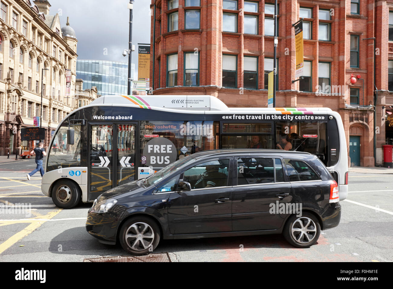 kostenloser Shuttle-Bus und Auto im Verkehr auf Deansgate Manchester City centre England UK Stockfoto