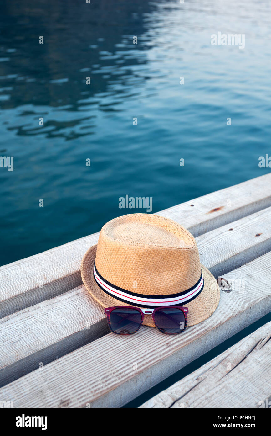 Sonnenbrillen, Flip-flops und Hut auf die hölzerne Struktur im Sommer. Stockfoto