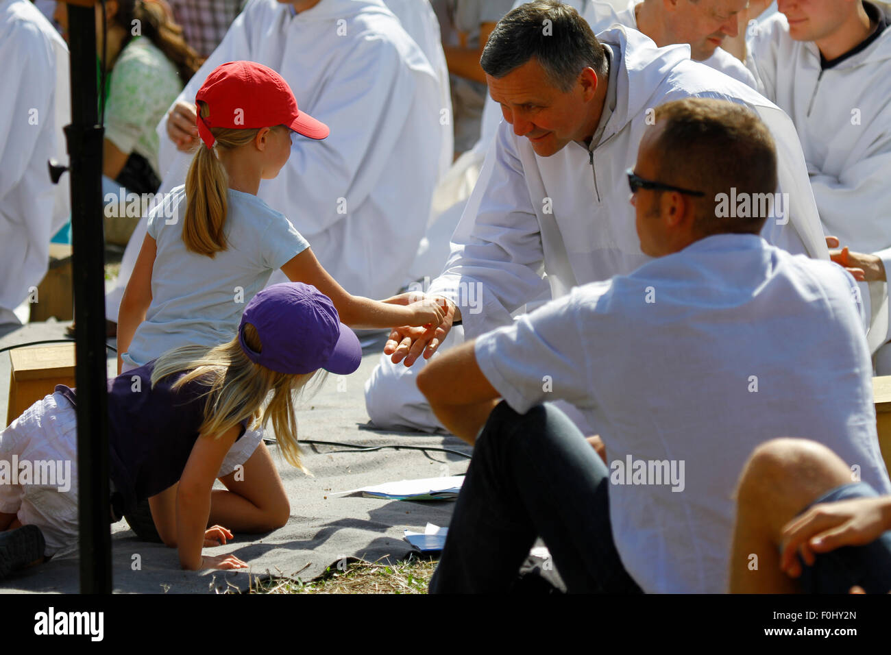 Burgund, Frankreich. 16. August 2015. Ein kleines Mädchen macht das Kreuzzeichen in die Handfläche einer der Brüder von Taizé. Die Brüder von Taizé, zusammen mit Tausenden von Pilgern und Führer der Kirche aus vielen verschiedenen Konfession, statt ein Gebet der Danksagung in Erinnerung von Frère Roger auf den 10. Jahrestag seines Todes und im Jahr seines 100. Geburtstages und den 75. Jahrestag seiner Ankunft in Taizé. © Michael Debets/Pacific Press/Alamy Live-Nachrichten Stockfoto