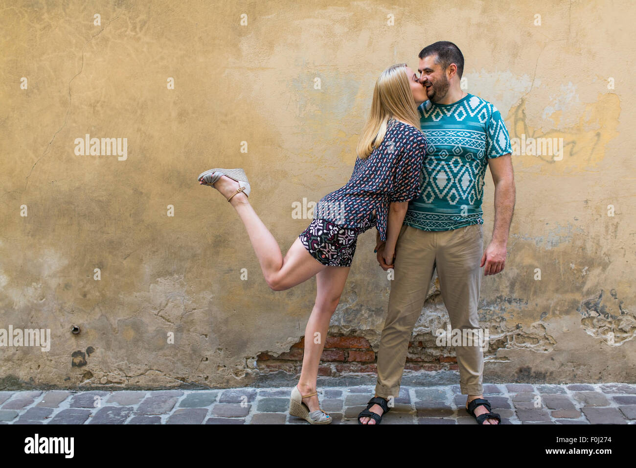 Glückliches junges Paar in Liebe Spaß gegen die Wand des Hauses. Stockfoto