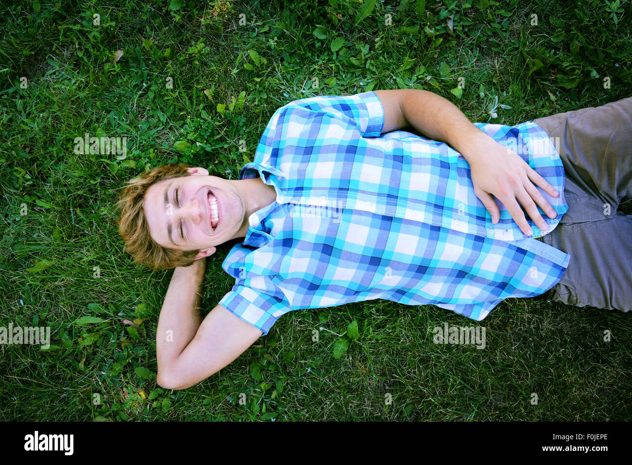 Junger Mann hat einen Rest auf dem Rasen Stockfoto