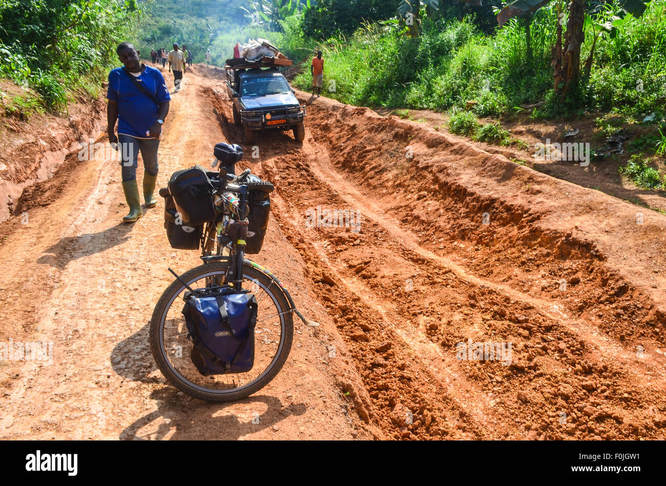 Rote Erde Feldweg in ländlichen Regionen Afrikas, Taxi entladen Passagiere eine schwierige Passage zu durchqueren Stockfoto