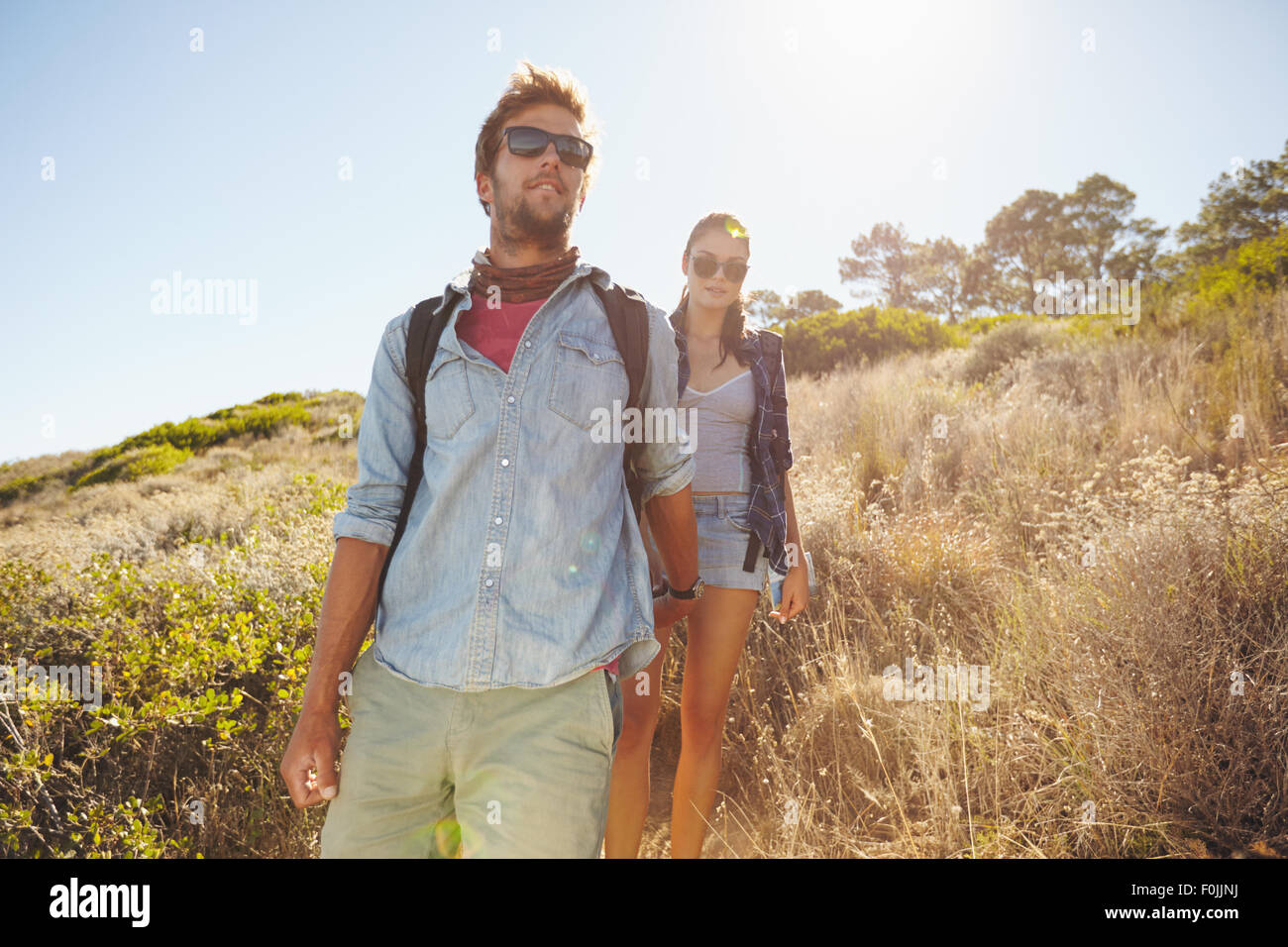 Bild des jungen Mannes mit seiner Freundin in Bergen wandern. Paar zu Fuß bergab, auf sonnigen Tag. Stockfoto