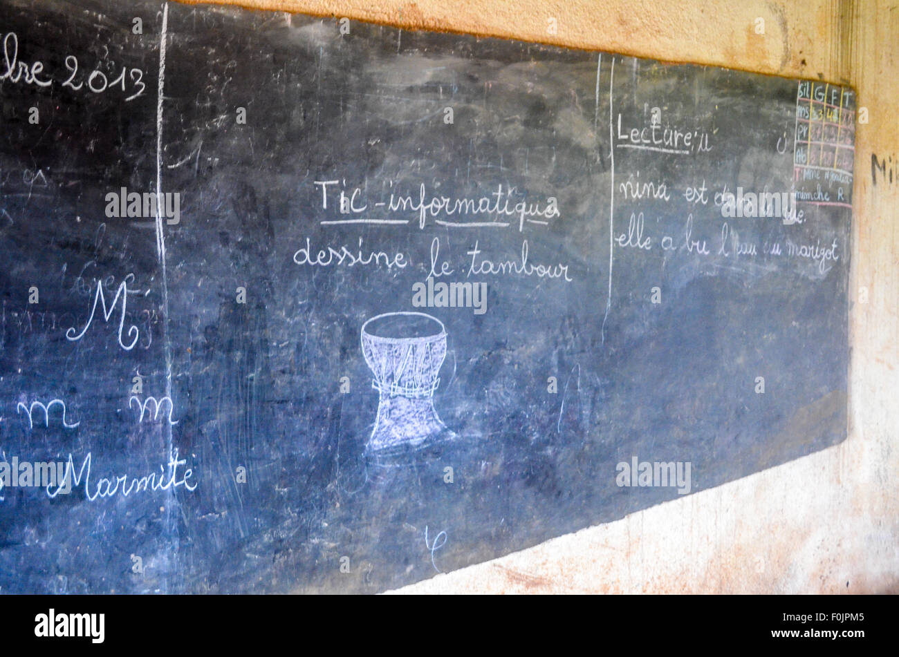 Schwarzes Brett in einer afrikanischen Dorfschule zeigt eine Trommel unter dem Titel "IKT - Informatik" und Kursteilnehmer, die Trommel ziehen Fragen. Stockfoto