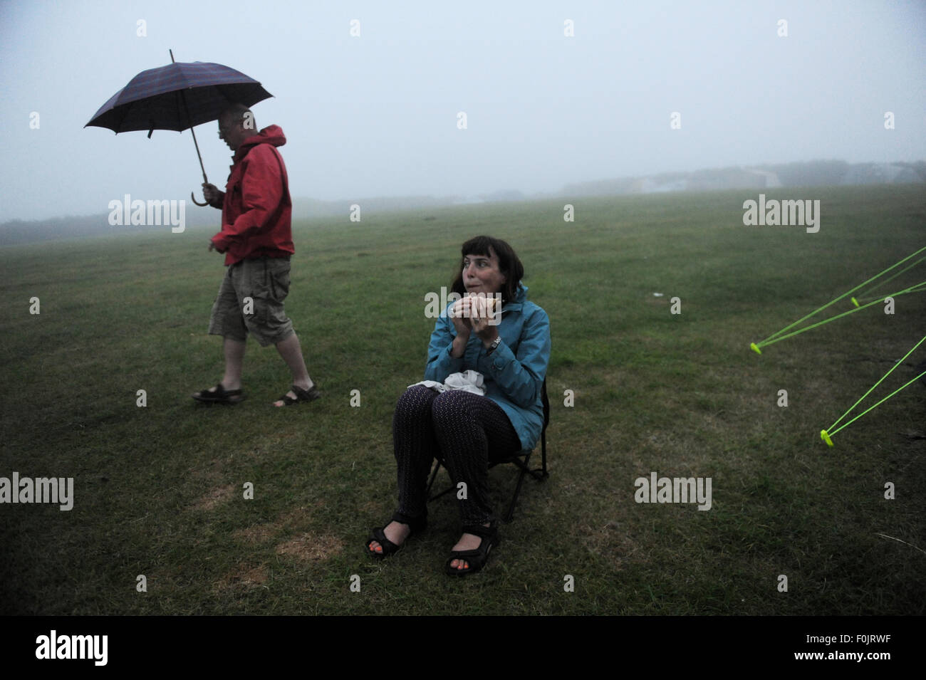Mann und Frau, die versucht, Suppper auf einem Campingkocher in Cornwall in Wind und Regen zu kochen Stockfoto
