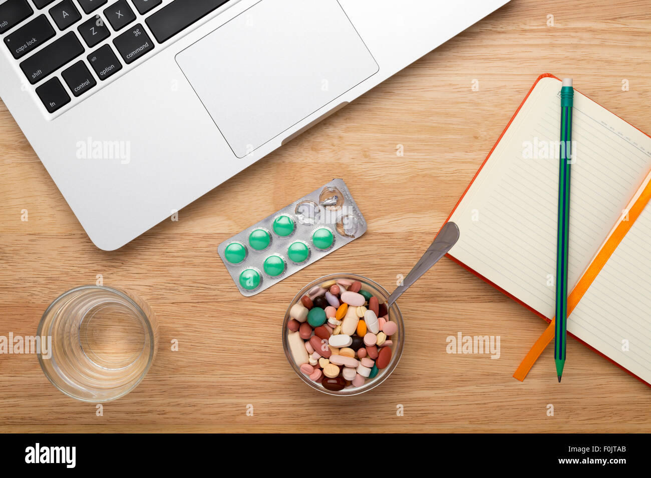 Antivirus-set mit grünen Pillen Blister Pack und Laptop auf Holztisch Stockfoto