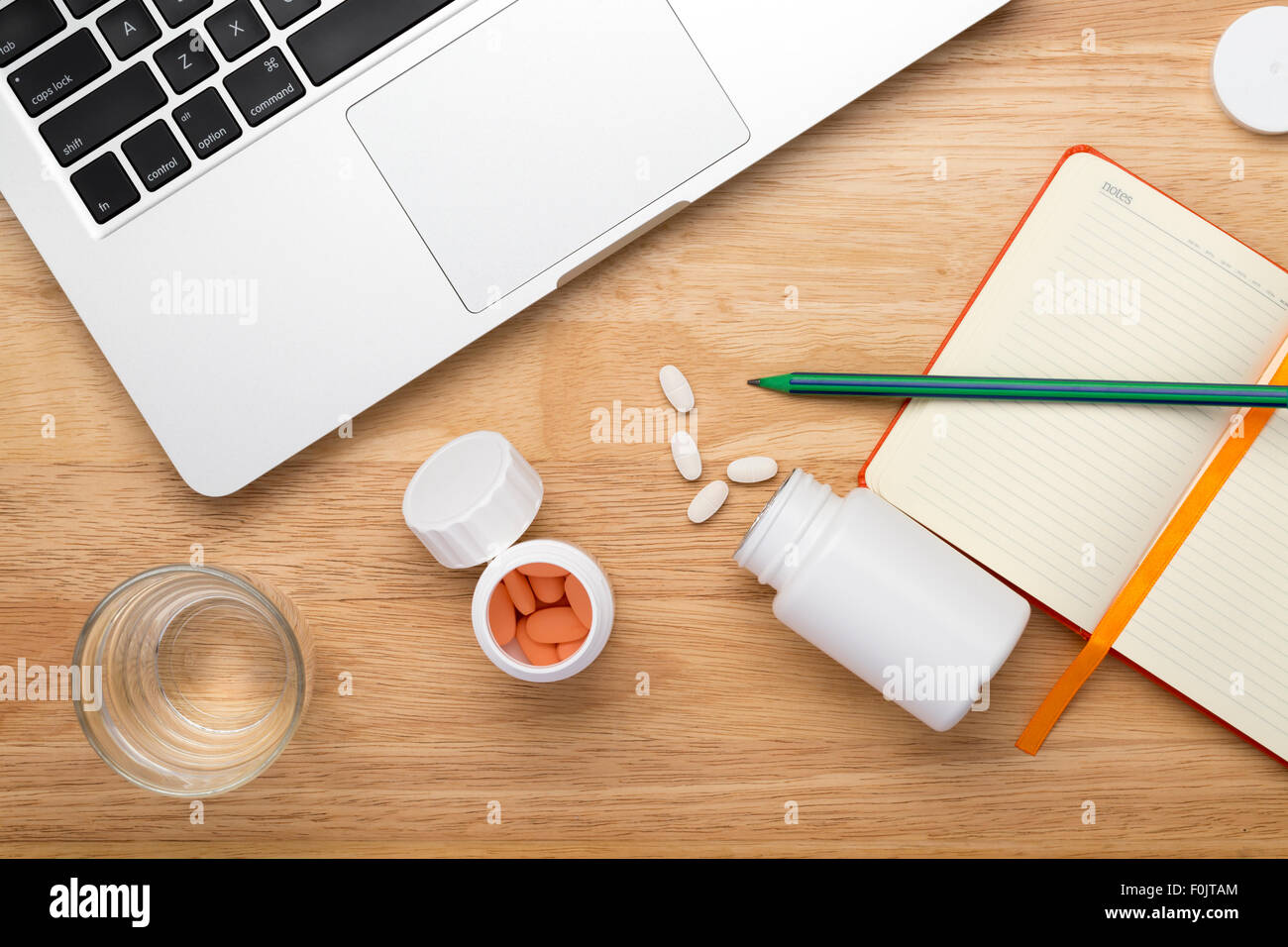 Anti-Stress set bestehend aus Pillen Flasche und Glas Wasser trinken auf Holztisch Stockfoto