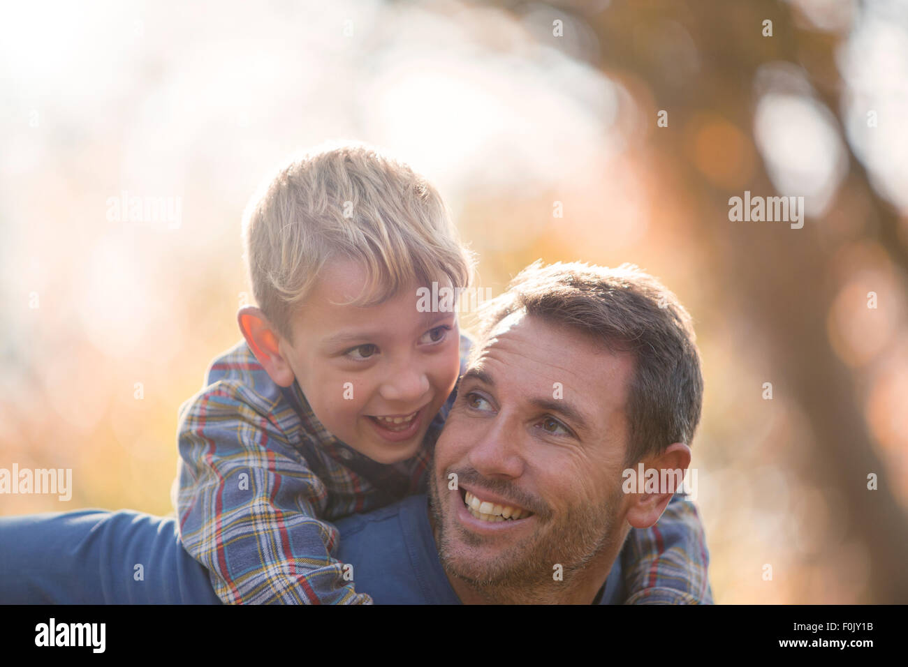 Liebevoller Vater und Sohn Huckepack Stockfoto