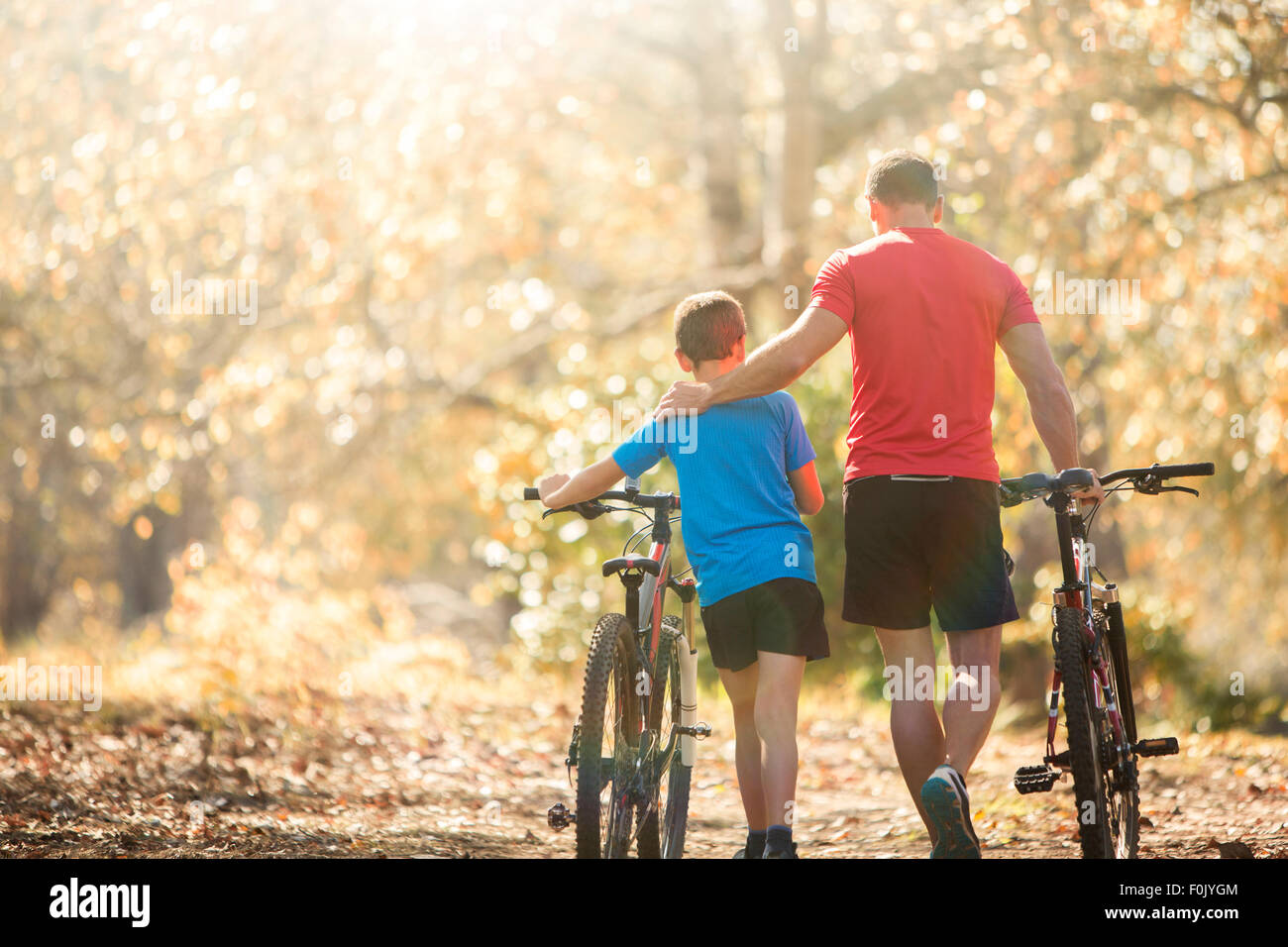 Liebevoller Vater und Sohn Mountainbikes Weg in den Wald zu gehen Stockfoto