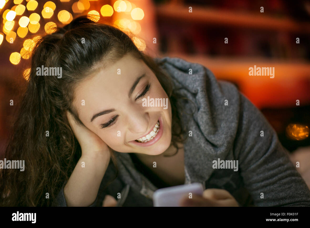 Lächelnde Teenager-Mädchen SMS mit Handy Stockfoto