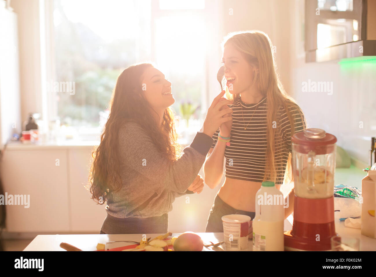 Teenager Mädchen spielen mit Löffel in sonnige Küche Stockfoto