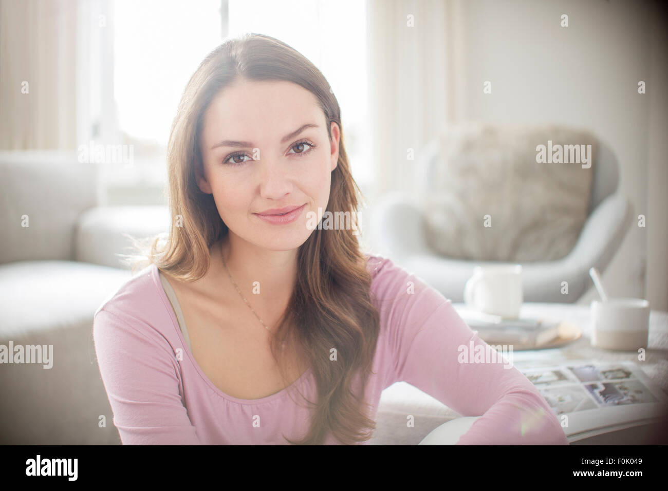 Lächelnde Frau Porträt im sonnigen Wohnzimmer Stockfoto