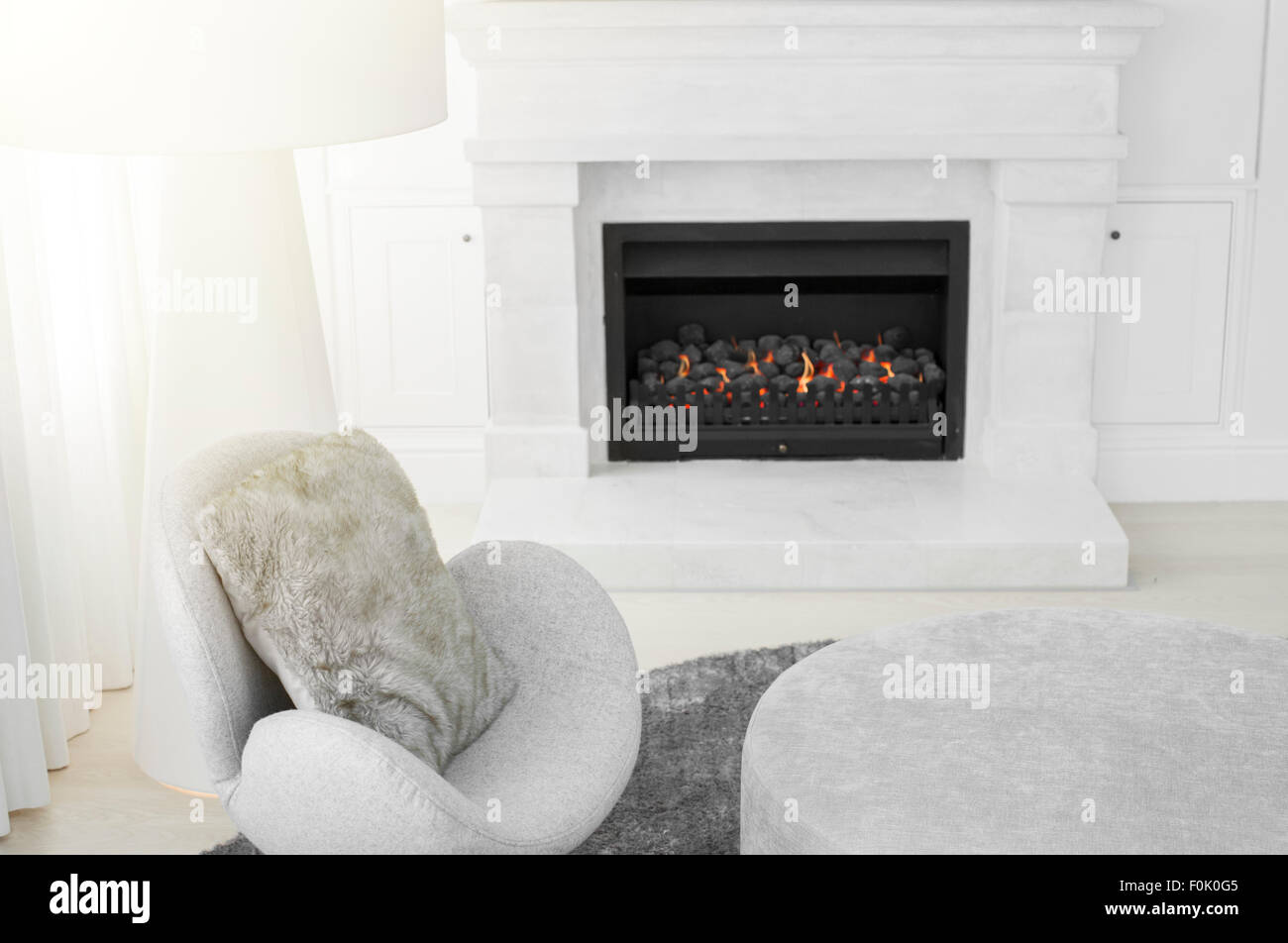 Moderner Stuhl und Stehlampe neben Marmor Kamin im Wohnzimmer  Stockfotografie - Alamy