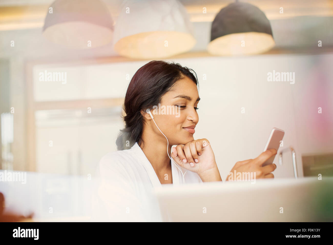 Frau mit Kopfhörern anhören von Musik auf MP3-player Stockfoto