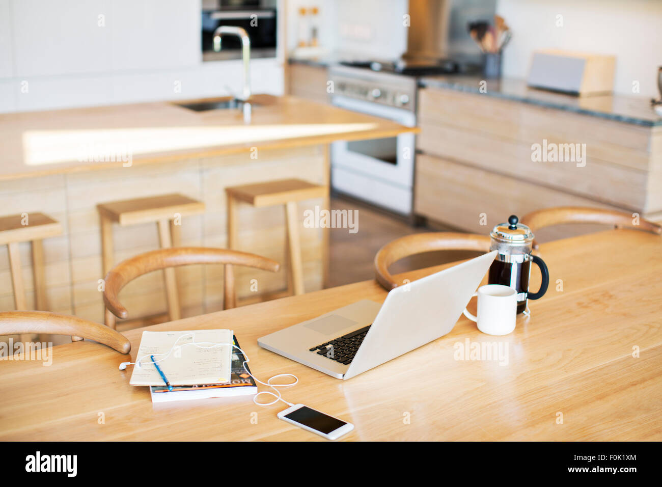 Laptop, drücken Sie Französisch Kaffee, Handy und Notebook am Küchentisch Stockfoto