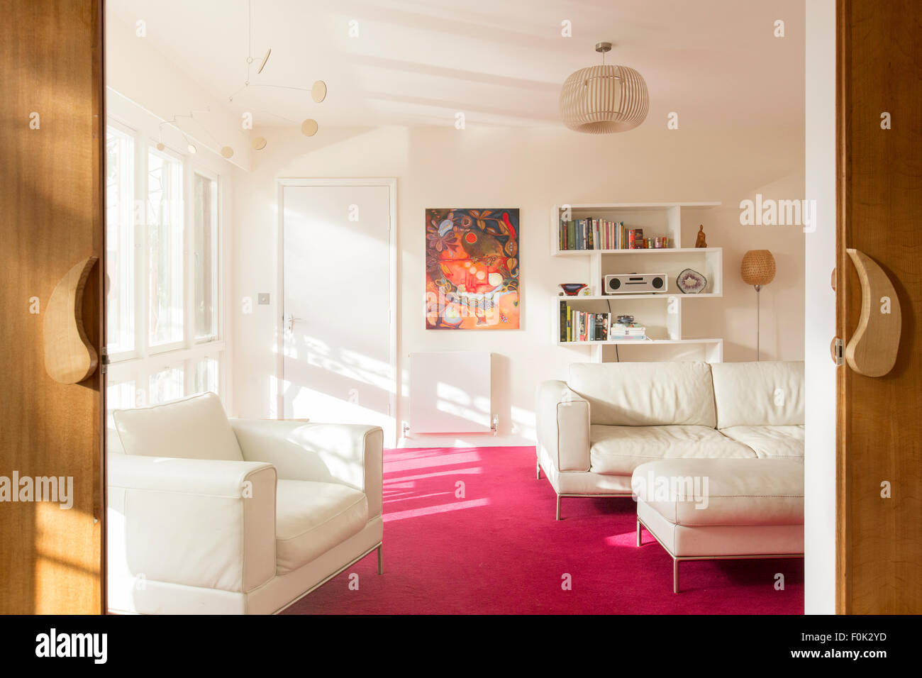 Helles Wohnzimmer mit weißem Ledermöbel Stockfoto