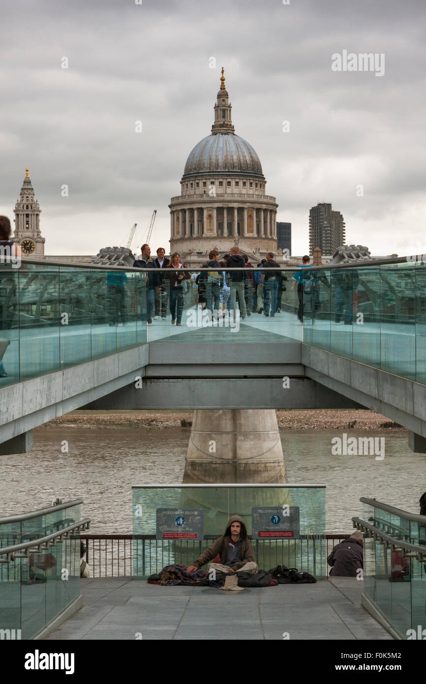 Ein Obdachloser Mann und Hund Betteln auf die Millennium Bridge, St. Pauls Cathedral in der Nähe; London, England GB Stockfoto