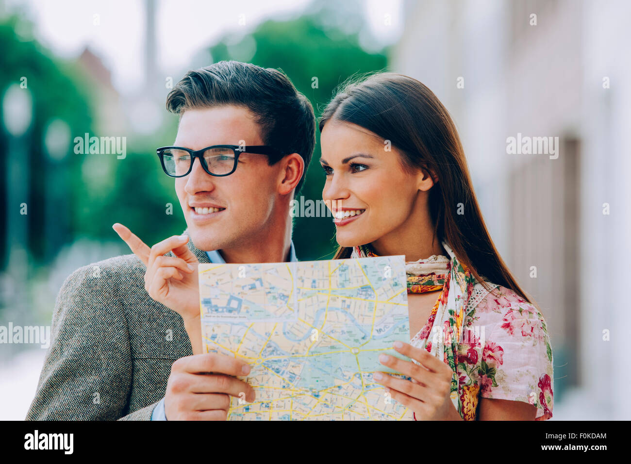 Junges Paar Holding Karte Suche nach rechts Richtung Stockfoto