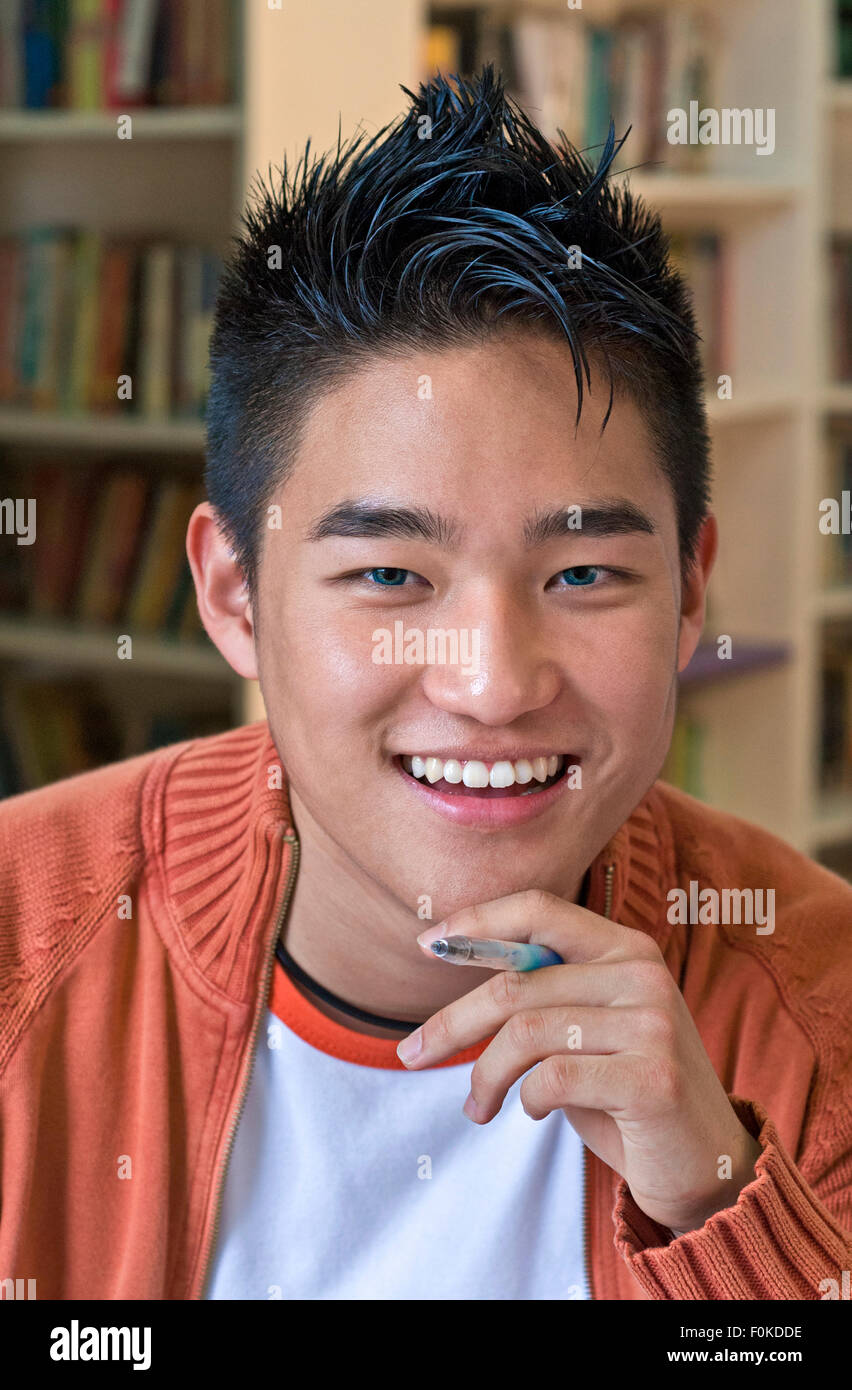 Schüler selbstsicher glücklich lächelnd Senior koreanischer asiatischer Teenager Schüler Portrait lächelnd und entspannend während seines Studiums in der Senior School Library Stockfoto