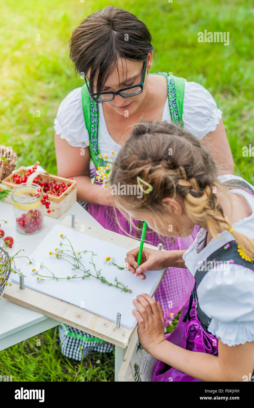 Deutschland, Sachsen, Mädchen tragen Dirndl Pflanzen zeichnen lernen Stockfoto