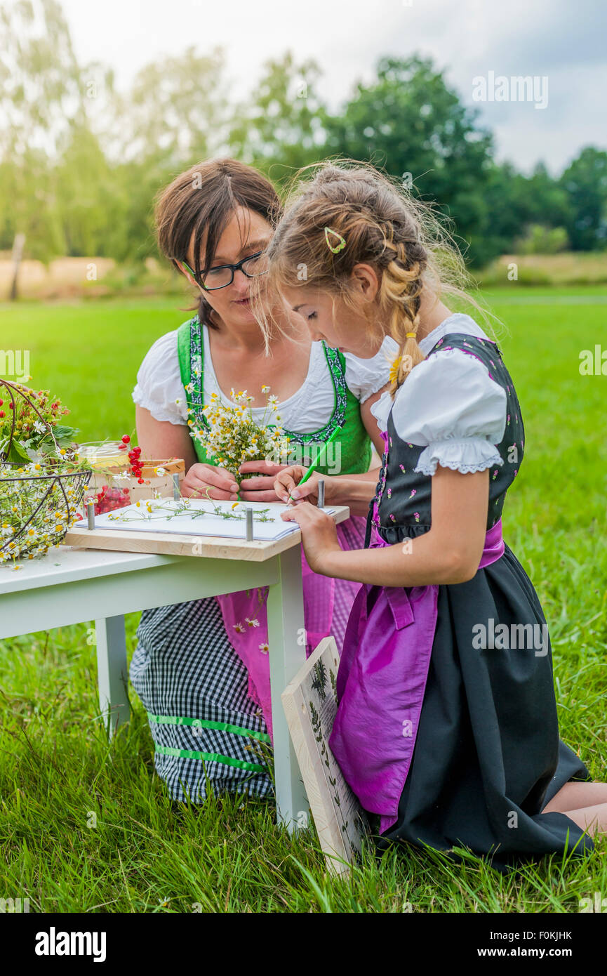 Deutschland, Sachsen, Mädchen tragen Dirndl Pflanzen zeichnen lernen Stockfoto