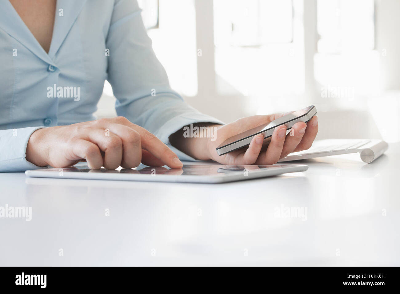 Nahaufnahme von Frauenhand mit Smartphone und Tablet-digital Stockfoto