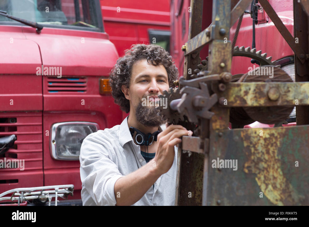 Junger Mann mit Kinn Bart Anpassung Baumaschine Stockfoto