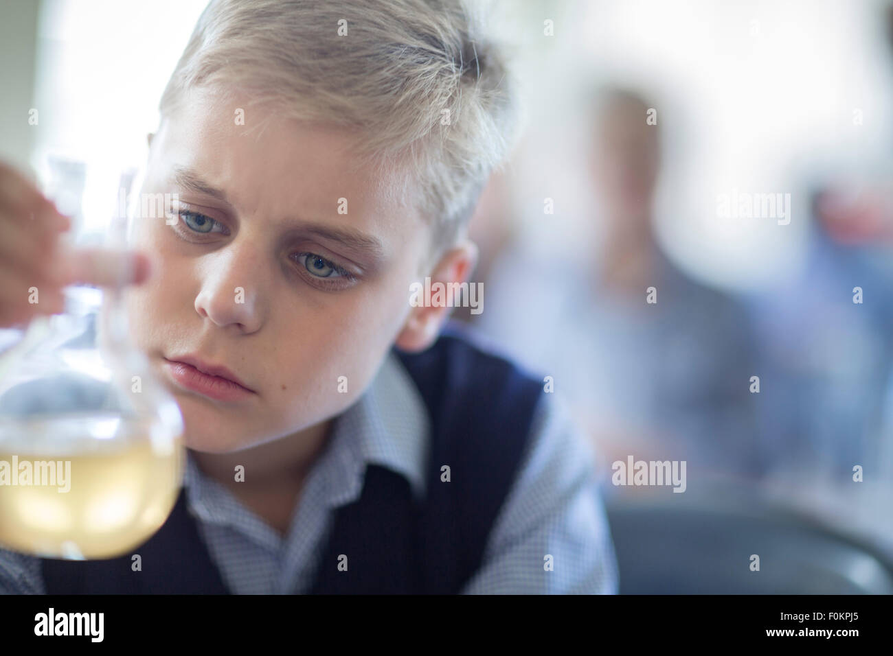 Schüler im Chemieunterricht betrachten Rundboden-Kolben Stockfoto