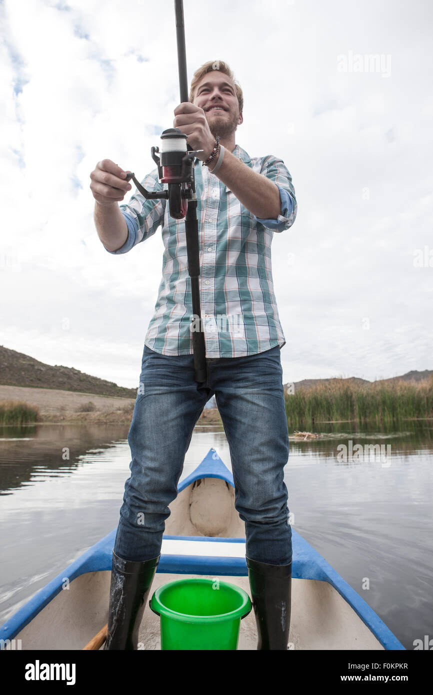 Jungen stehen in einem Kanu auf dem See angeln Stockfoto