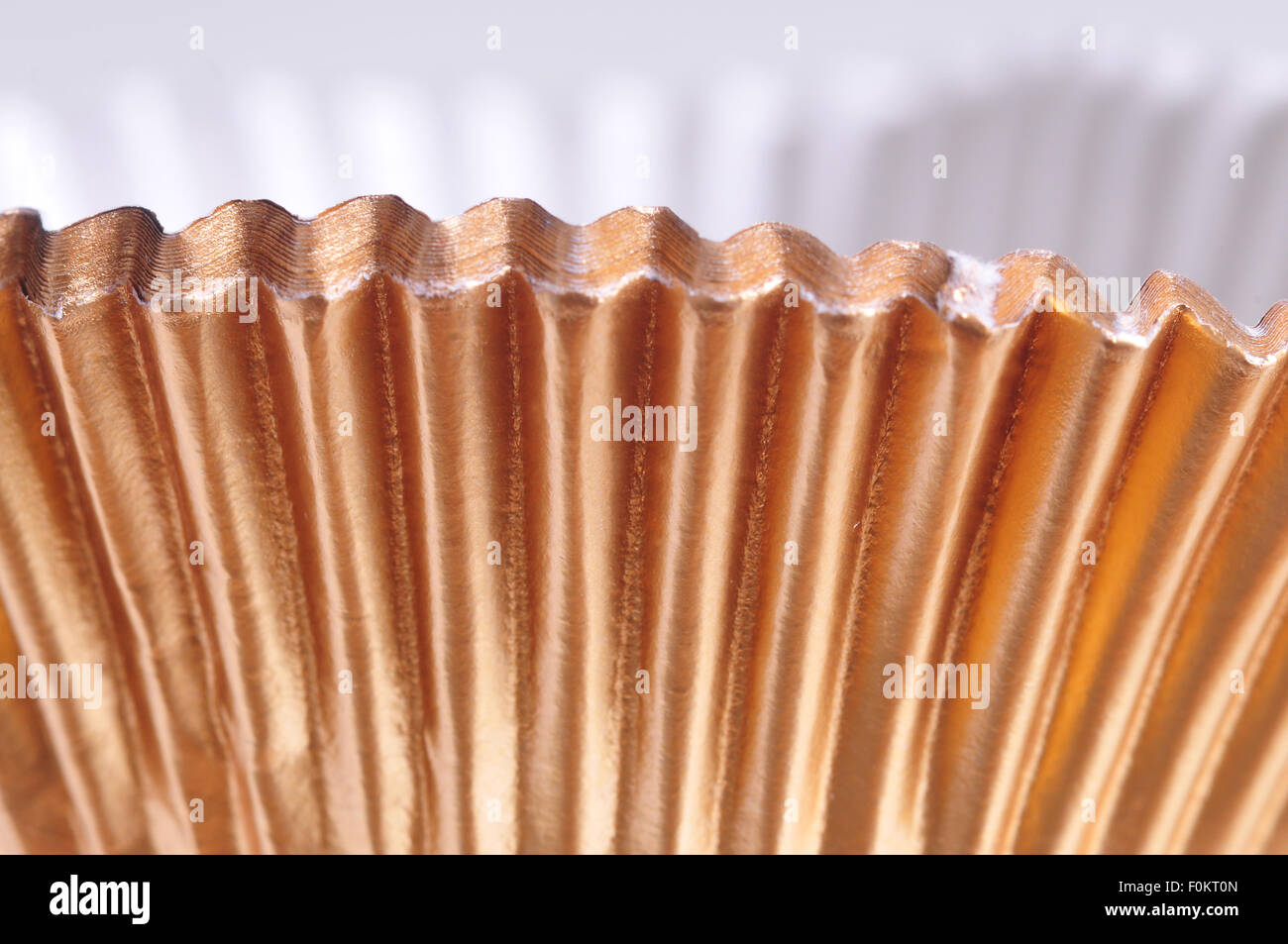 Makroaufnahme von golden Backen Tassen isoliert auf weiss Stockfoto