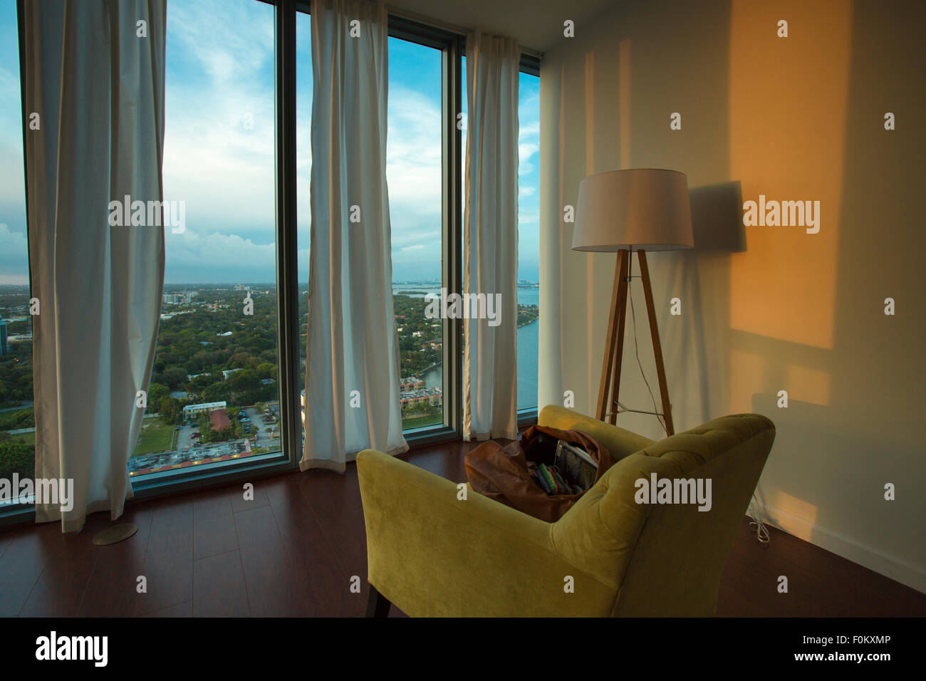 Innenraum einer möblierten Wohnung mit Blick auf Miami Beach. Die Möbel sind nur einen Stuhl und eine Lampe. Stockfoto
