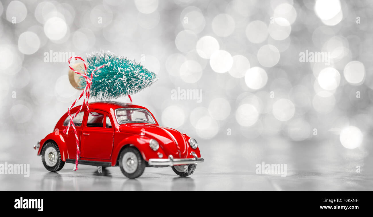 Miniatur rotes Auto mit Tanne auf abstrakten Hintergrund Stockfoto