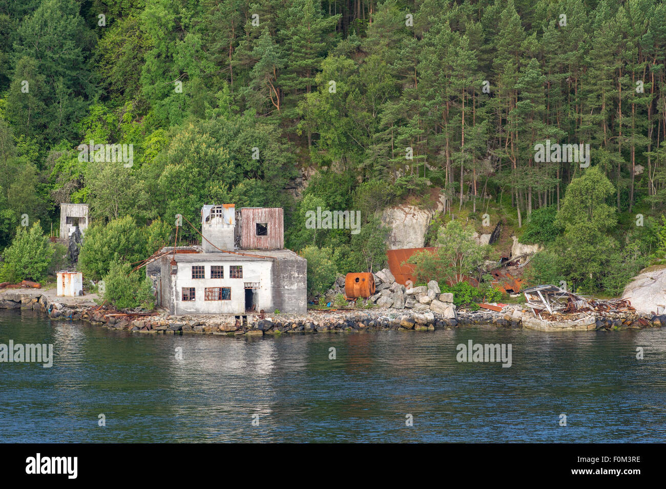 Alte, verlassene und verfallende Gebäude an der Seite von einem Fjord in der norwegischen Stadt Bergen. Stockfoto