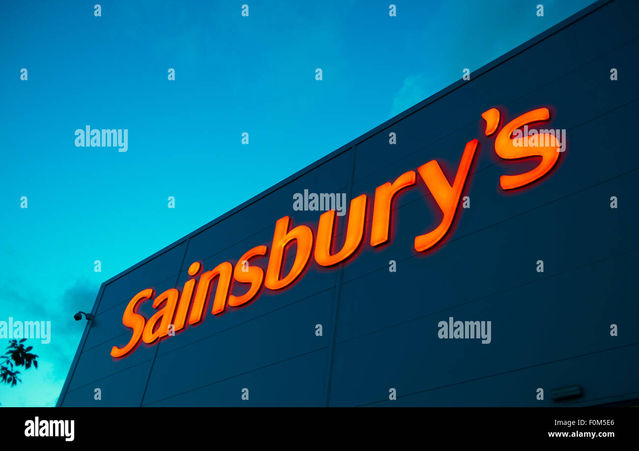 Sainsbury-Logo in der Dämmerung beleuchtet Stockfoto