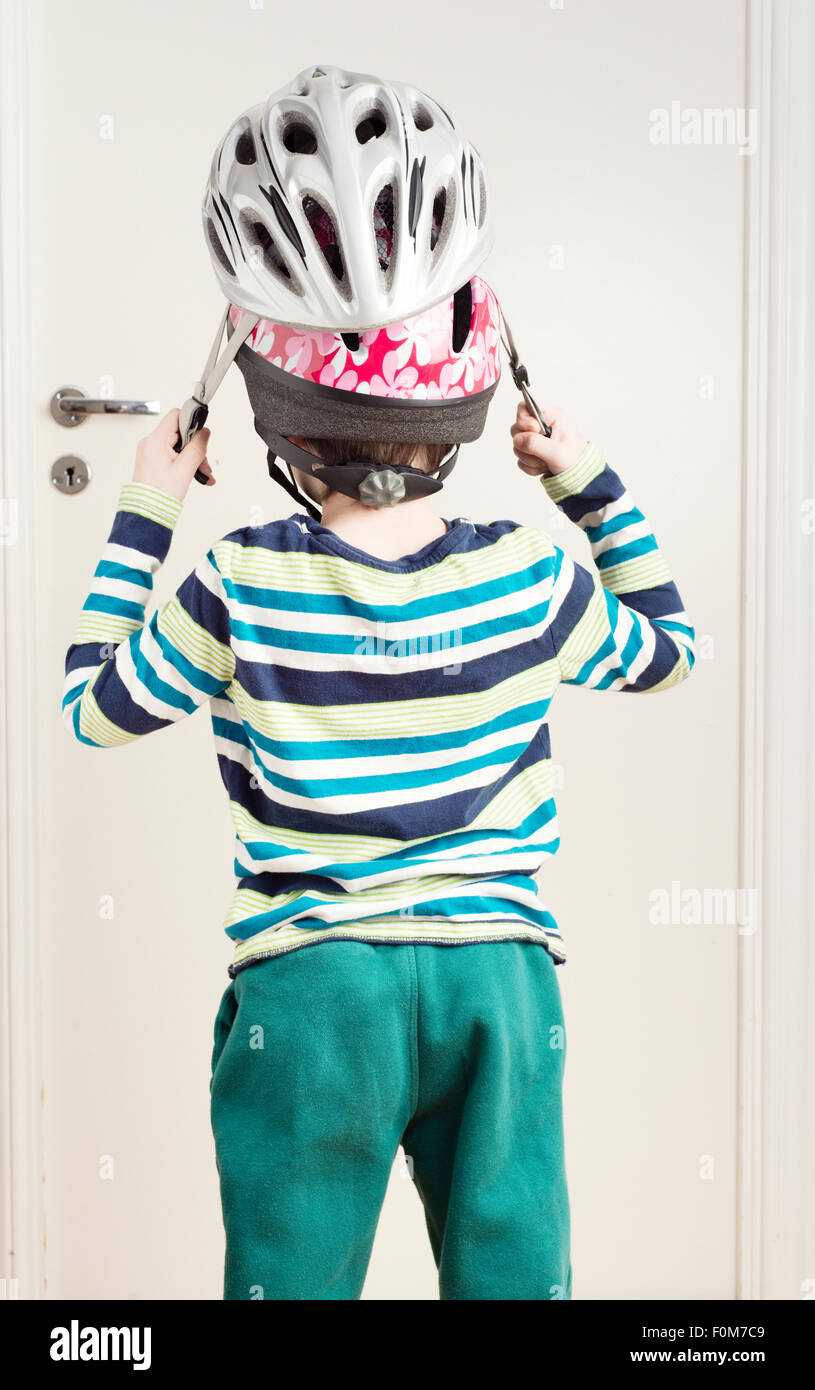 Kleines Mädchen auf zwei Fahrradhelme für zusätzlichen Schutz. Konzeptbild Sicherheitsschutz für Kinder lernen Stockfoto