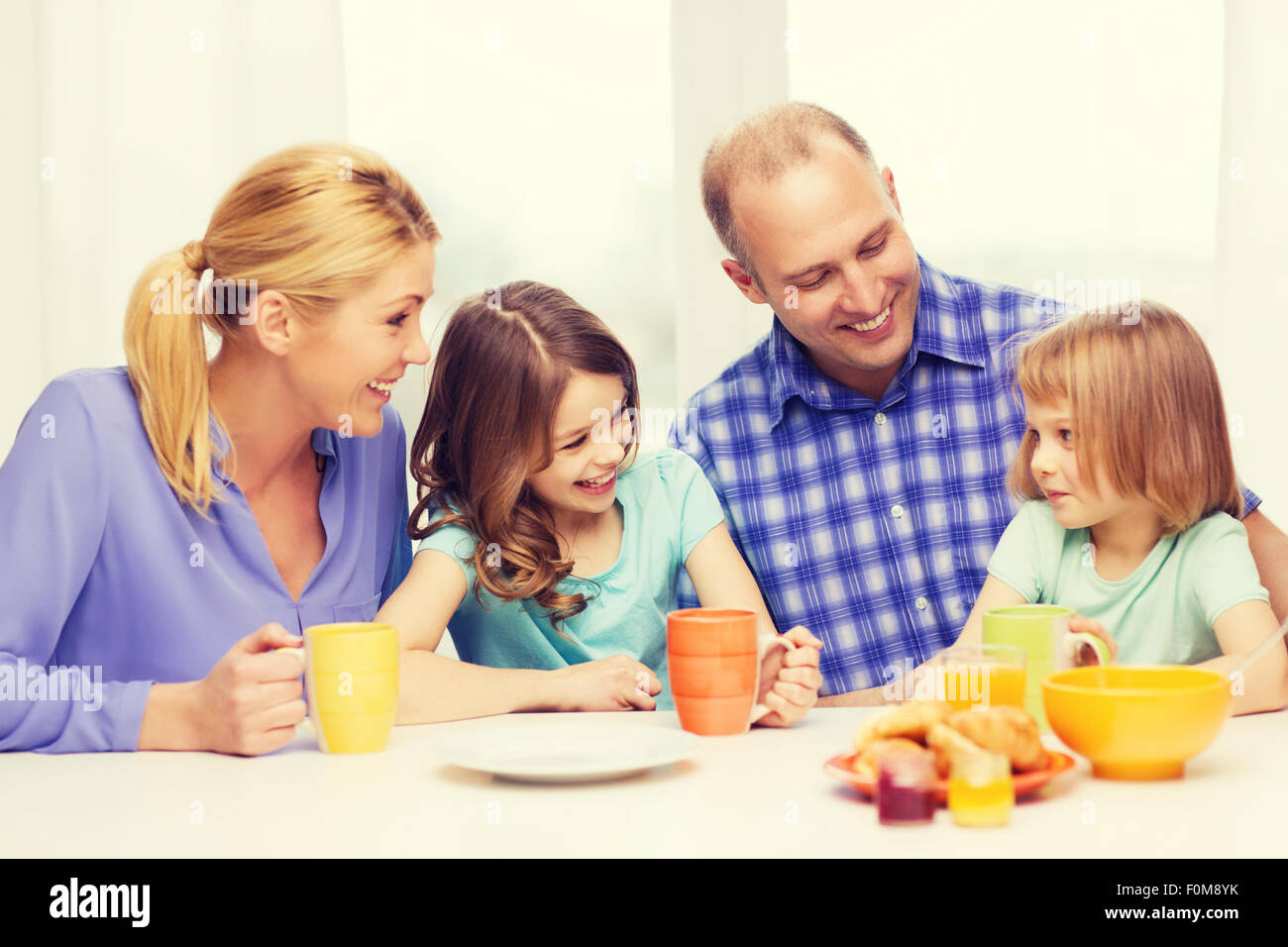 glückliche Familie mit zwei Kindern mit dem Frühstück Stockfoto