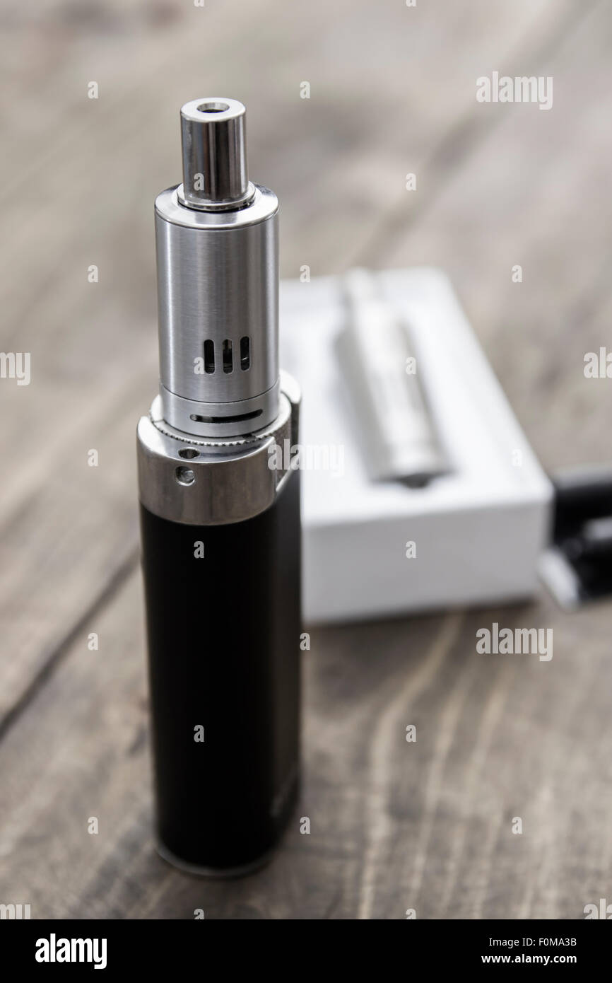 Dampfen mod e-Zigarette mit Tank-Zerstäuber und Saft-Flaschen über Holz  Hintergrund Stockfotografie - Alamy