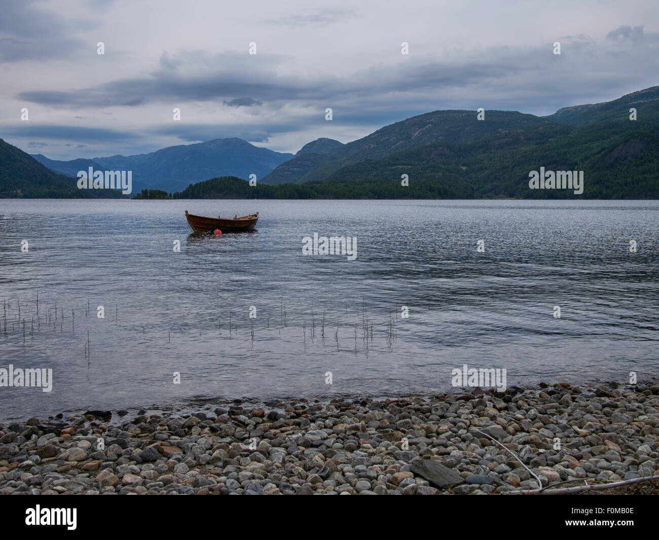 Epische norwegische Landschaft, Wasser, Strand, Berge, Holzboot Stockfoto
