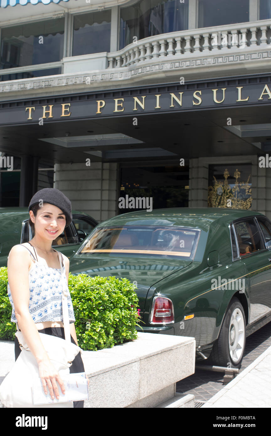 Touristen mit legendären grünen Rolls Royce außerhalb The Peninsula Hotel Hong Kong. Stockfoto