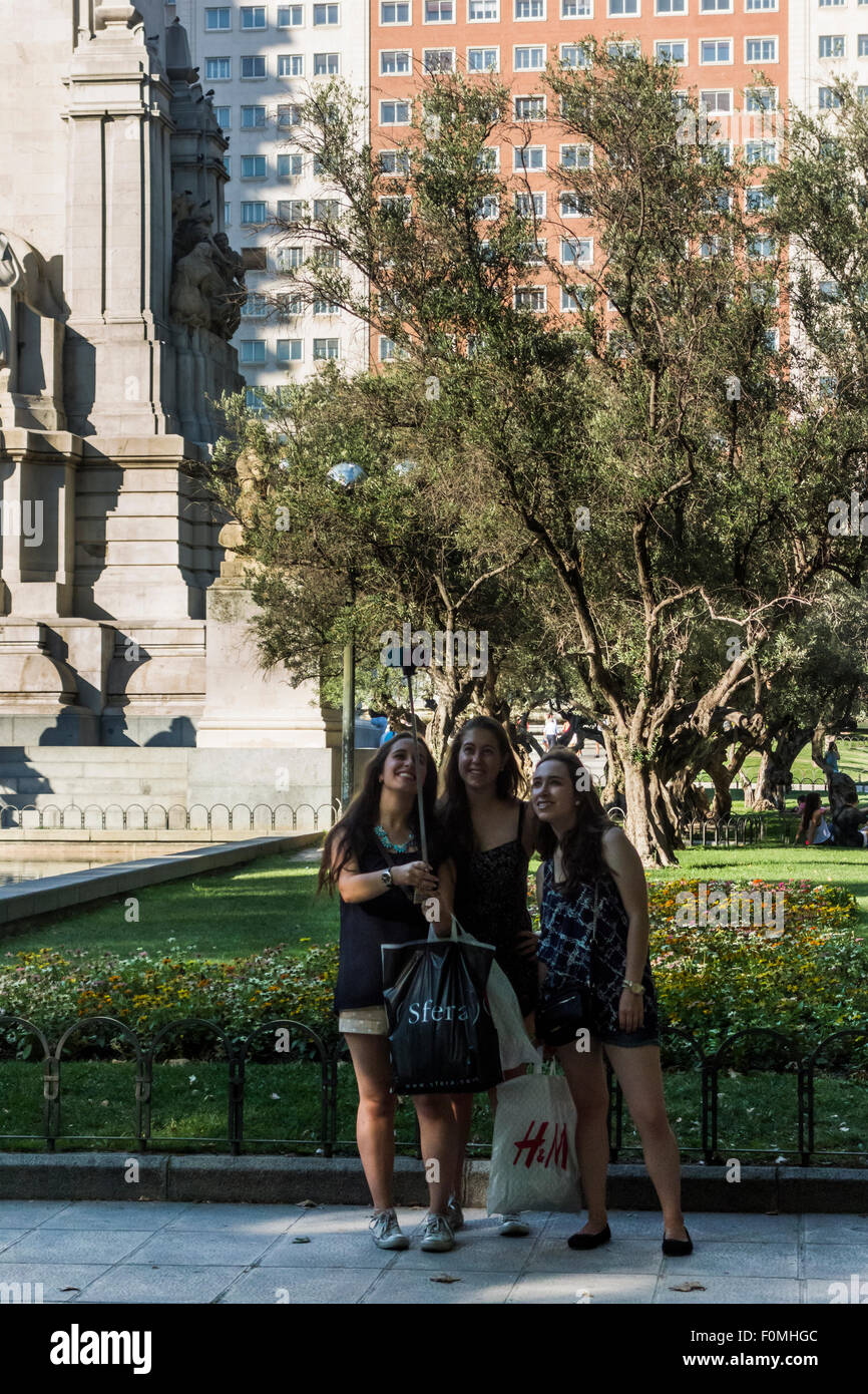 drei Mädchen, die die Selfie neben Cervantes-Denkmal, Plaza de España, Madrid, Spanien Stockfoto