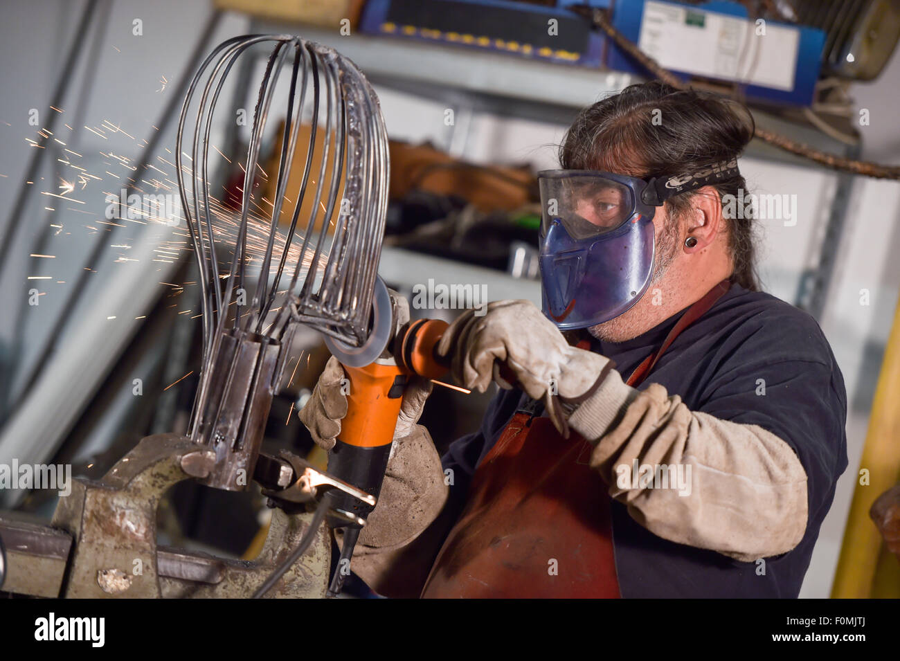 Metallarbeiter in Werkstatt Schleifen mit Funken Stockfoto