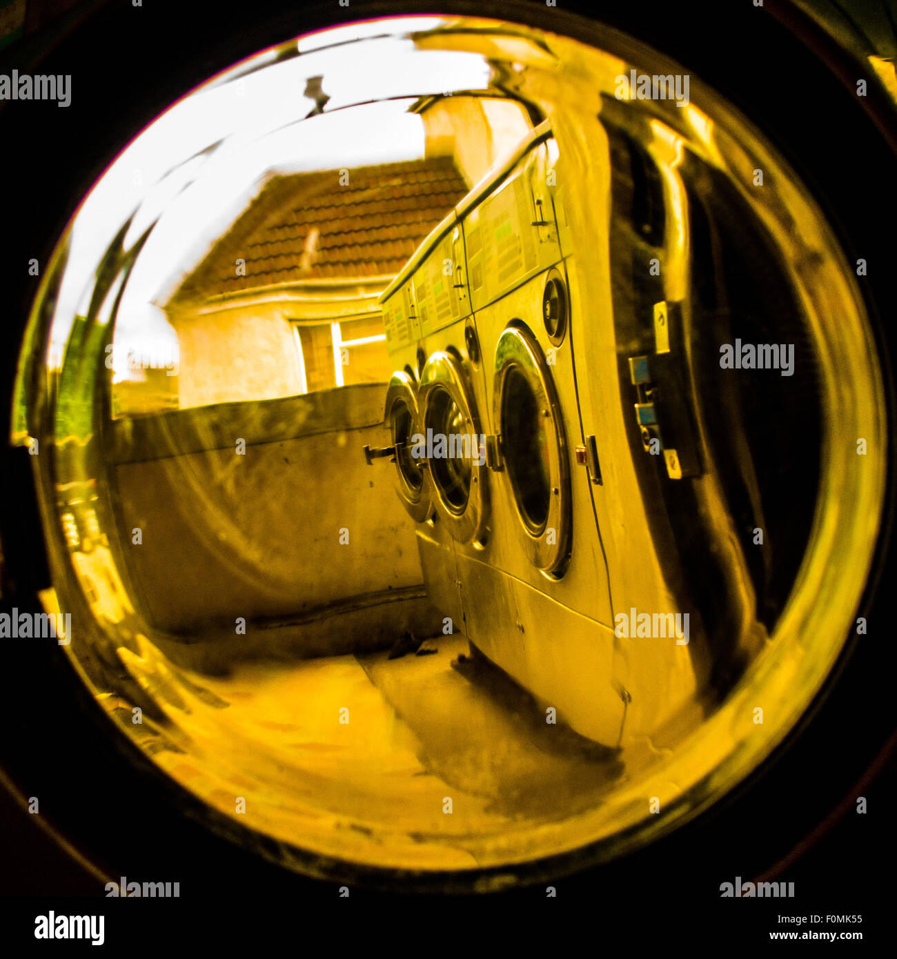 Waschsalon-Waschmaschinen durch Glastür Stockfoto