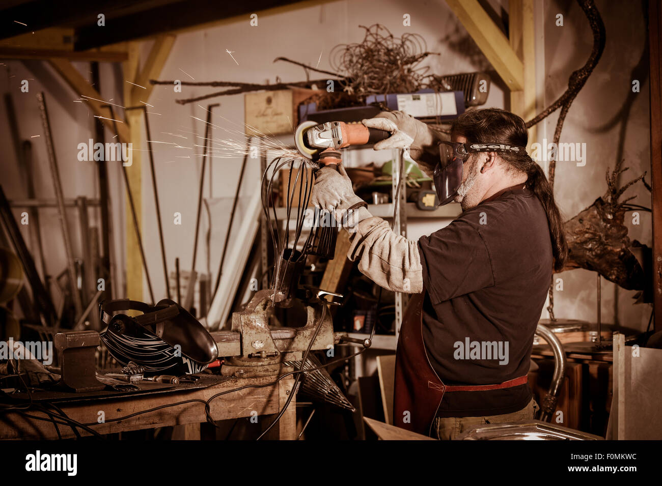 Metallarbeiter in Werkstatt Schleifen mit Funken Stockfoto