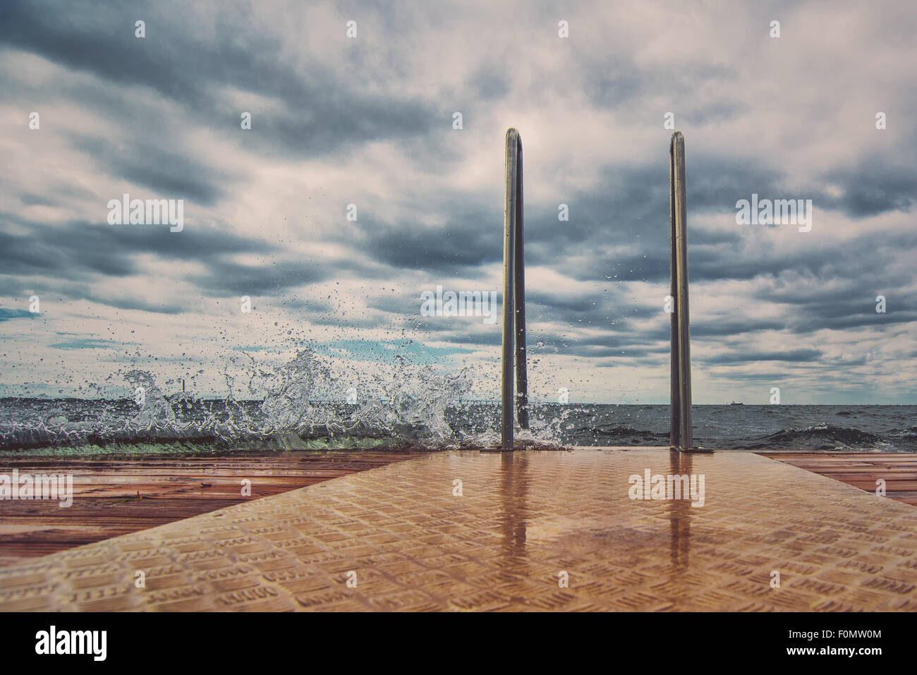 Hölzernen Ozean Pier an stürmischen Tag, Wellen plätschern Stockfoto