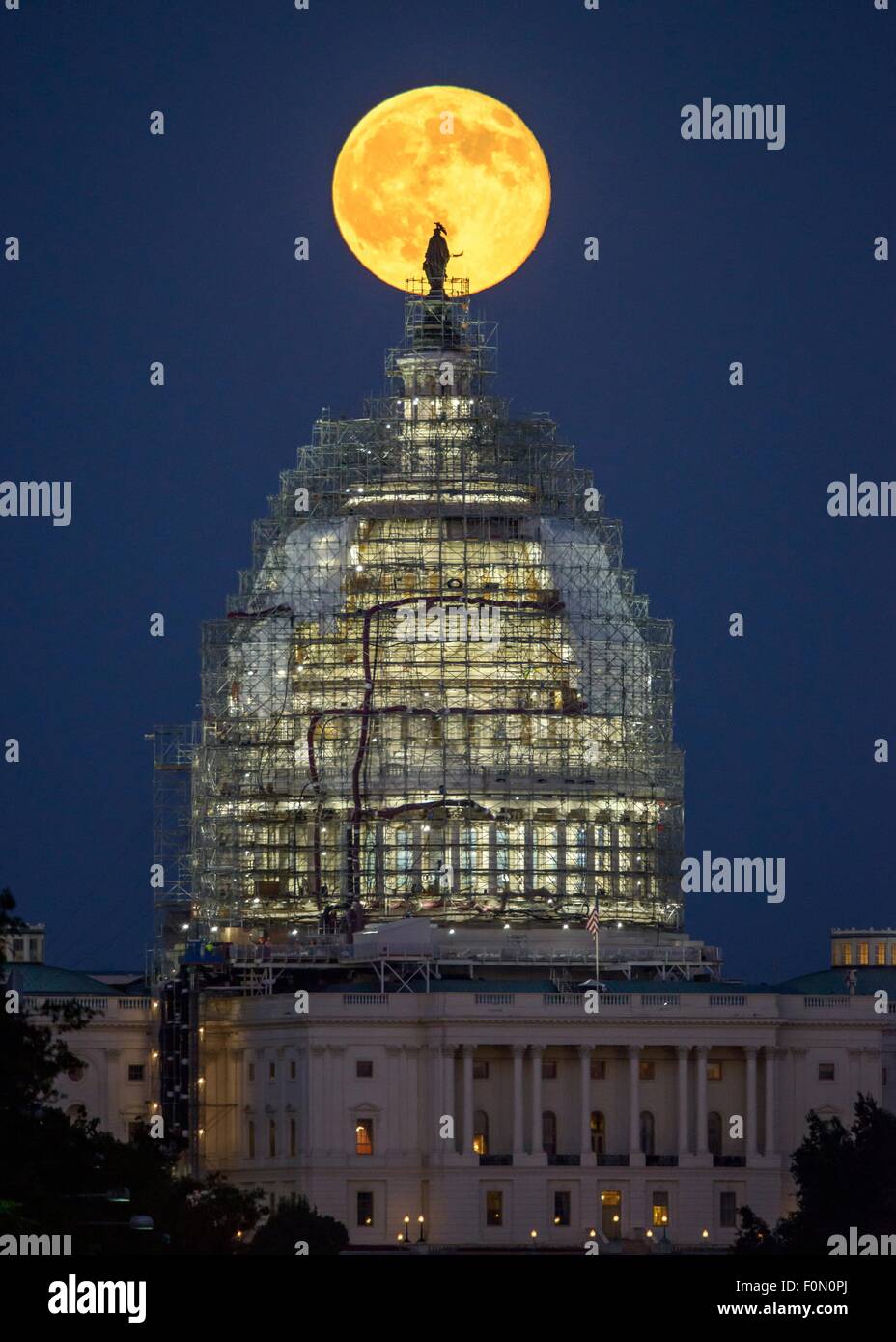 Ein zweite Vollmond für den Monat Juli steigt hinter der Kuppel des Kapitols, die derzeit im Gerüstbau für Restaurierung 31. Juli 2015 in Washington, DC gezwängt. Zwei Vollmonde im selben Monat gekennzeichnet häufig als ein Blue Moon. Stockfoto