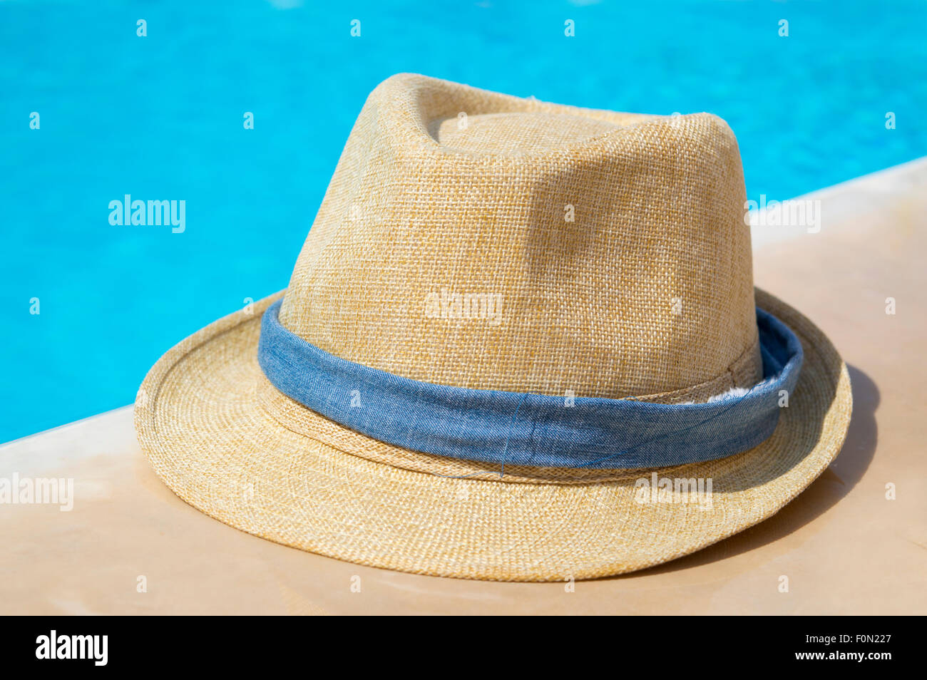 Strohhut mit blauen Band am Pool Stockfoto