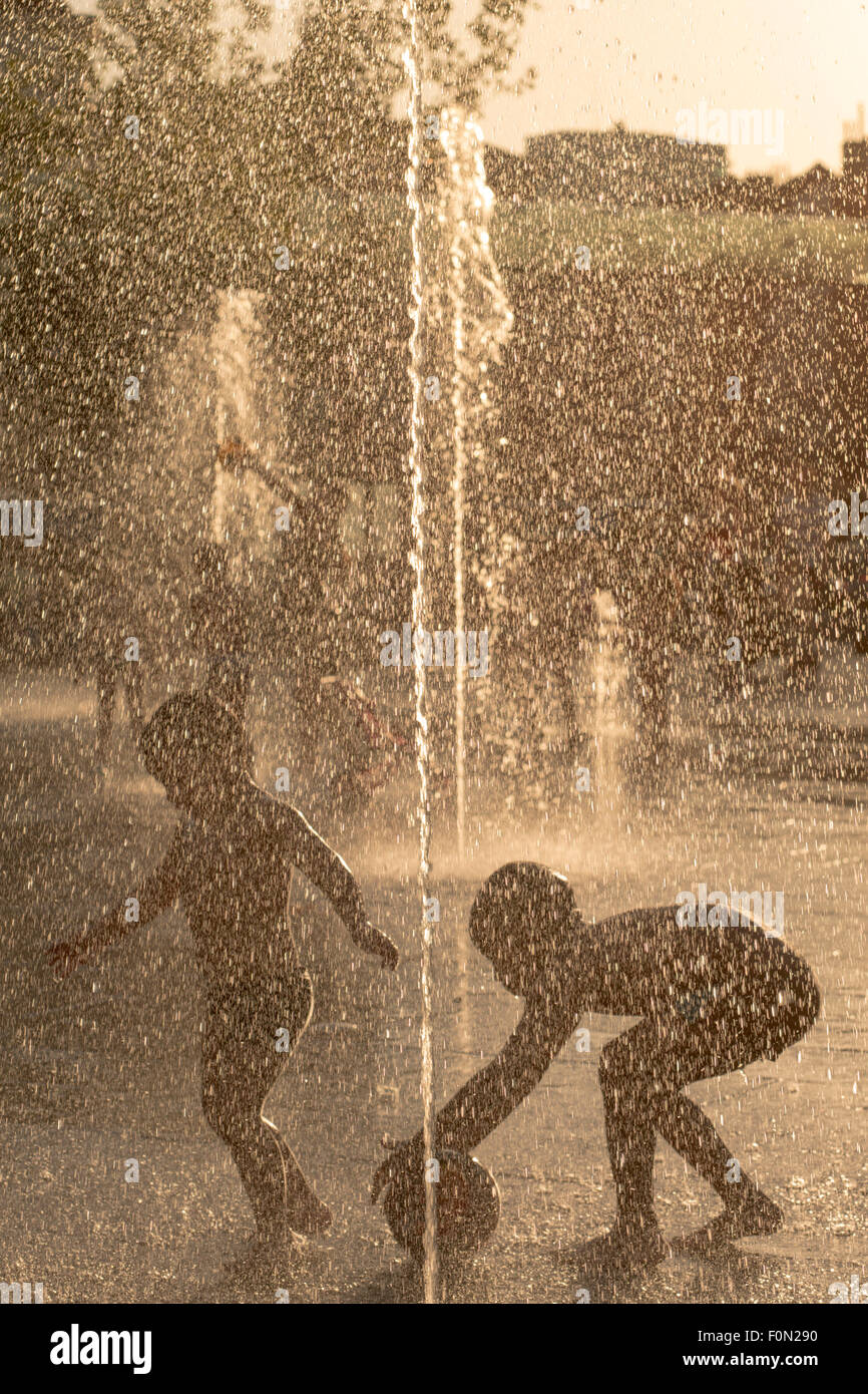 Jungs spielen mit einem Ball in einen öffentlichen Brunnen in Place Flagey, Brüssel, Belgien Stockfoto